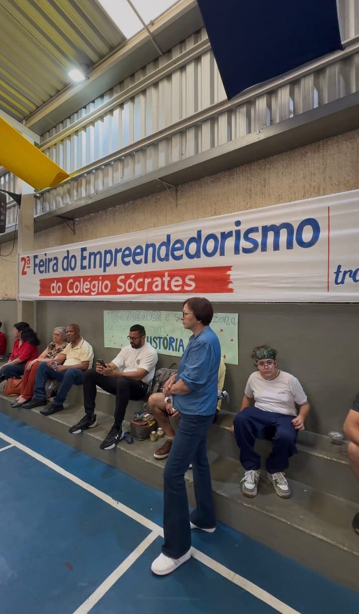 Faixa da 2ª Feira do Empreendedorismo do Colégio Sócrates na quadra, com famílias sentadas na arquibancada